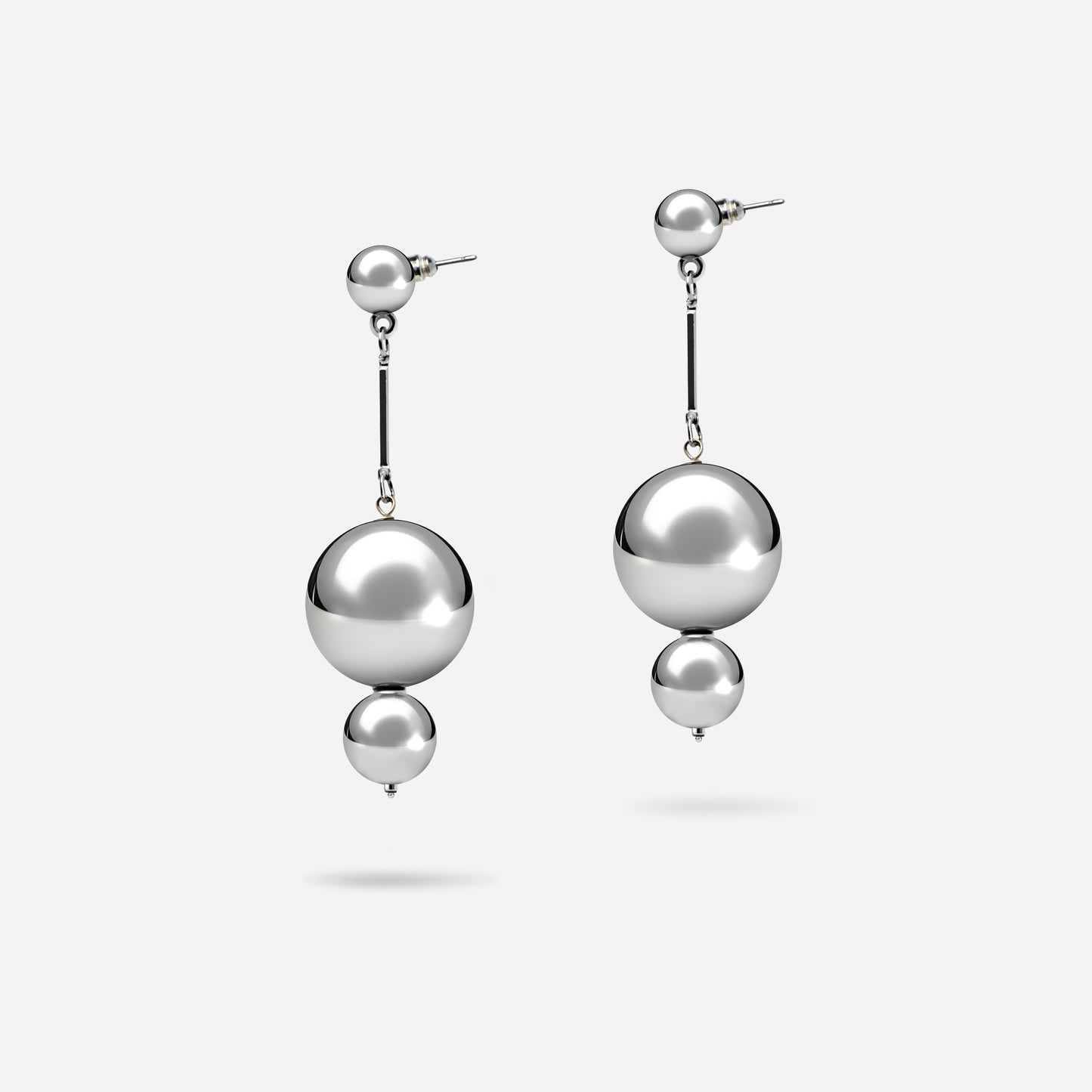 Diese Statement-Ohrringe bestehen aus zwei versilberten Kugeln, die eine elegante Schlichtheit ausstrahlen. Die größere und kleinere Kugel sorgen für ein harmonisches Design mit hohem Effekt – perfekt, um mit einem schwarzen Kleid zu glänzen. Ein eleganter Blickfang für besondere Anlässe.
