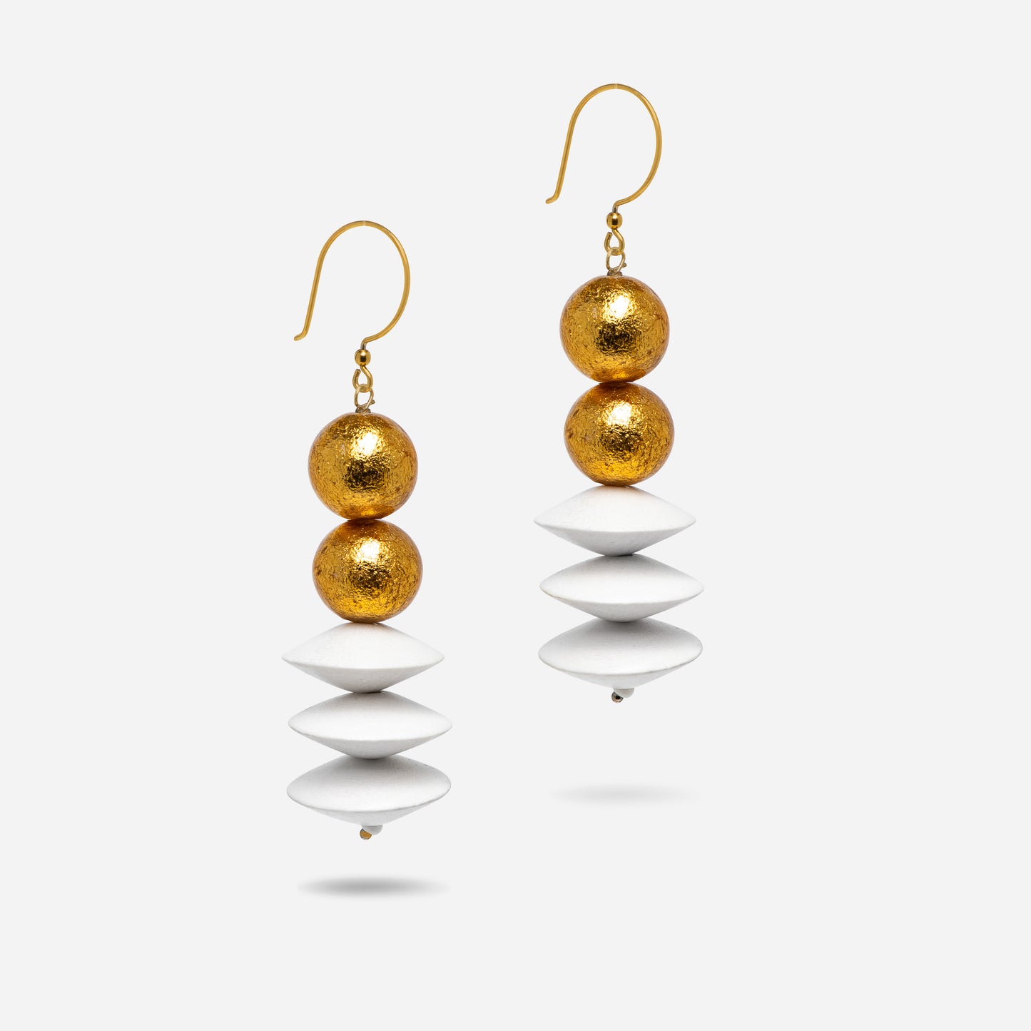 In der Buddha-Kollektion erstrahlen diese Ohrringe durch eine Kombination aus goldenen Holzkugeln und weißen Holzscheiben. Mit 18 Karat vergoldeten Sterling-Silber-Ohrhaken sind sie ein Ausdruck von Harmonie und zeitloser Eleganz.
