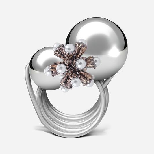 Mit seiner festlichen Eleganz und kunstvollen Gestaltung zieht dieser Ring aus der Weihnachtskollektion alle Blicke auf sich. Zwei versilberte Kugeln in verschiedenen Größen bilden die Basis, während ein florales Element mit filigranen Perlen dem Design eine winterliche und verspielte Note verleiht. Die Kombination aus glänzenden Oberflächen und detaillierten Akzenten macht diesen Ring zu einem idealen Accessoire für die Feiertage und verleiht jedem Outfit einen stilvollen, festlichen Touch.